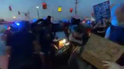 Cop drives through a crowd of protesters