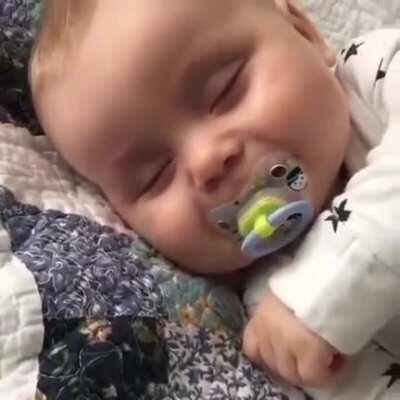 This baby is asleep but whenever his mom laughs, he recognises her voice, imitates her and laughs as well. (Better with sound on)