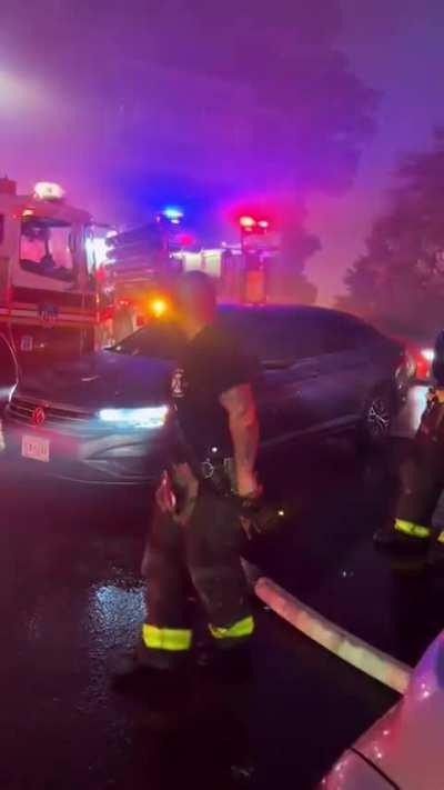 Dude drives over a firehose to get gas while fireman are putting out a fire