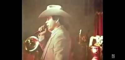 Chalino Sanchez reading the death note handed to him by an audience member, realizing this will be his last performance.