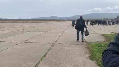 Scenes at an airfield in Russia's Far East where one man mobilised to fight in Ukraine was so drunk that he reportedly fell asleep in the long grass next to the runway