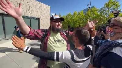 Man with Dave sign clashes with protesters at the Netflix Trans solidarity walkout.