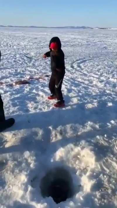 Boy catches fish the same size as himself.