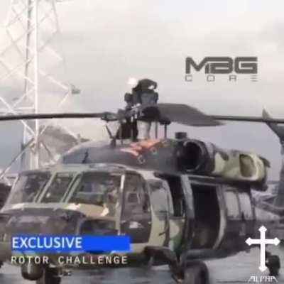 Man goes for a spin on the helicopter rotor blades