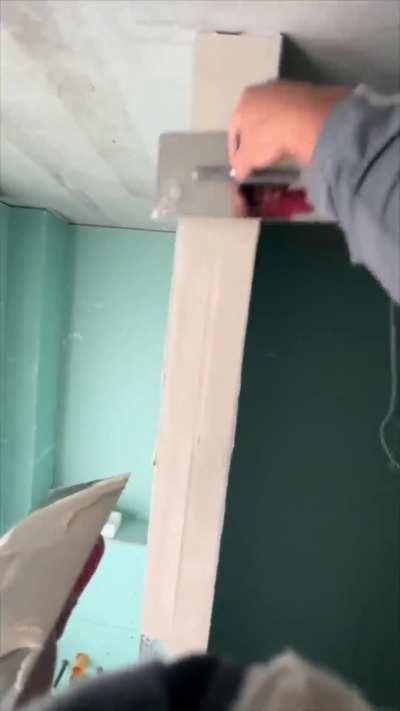 Drywall plastering a wall