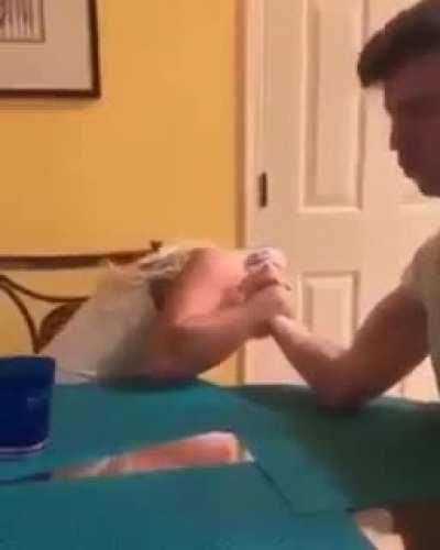 A guy and a girl arm wrestle. The girl wins.