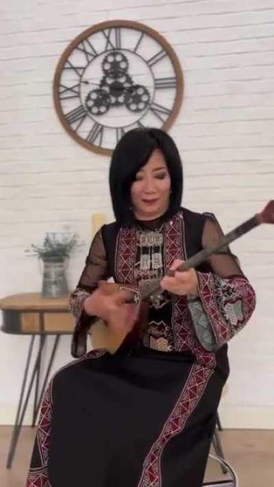 Kazakh artist Aigul Ulkenbayeva performs the Ukrainian patriotic folk song 'Oi u Luzi Chervona Kalyna' ('Oh the Red Viburnum in the Meadow') on the dombra, a traditional long-necked Kazakh lute