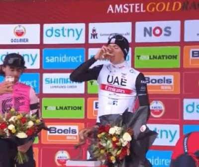 Not content with winning the bike race, he asserts podium beer dominance