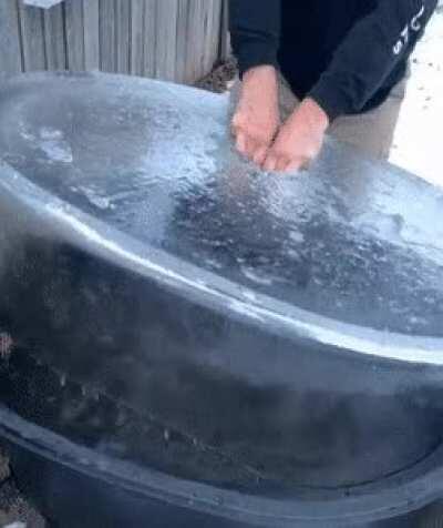 Pulling ice out of a water tub on a Canadian winter morning