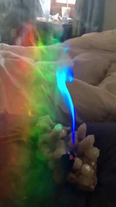 Smoke of Palo santo going through the light of a prism.