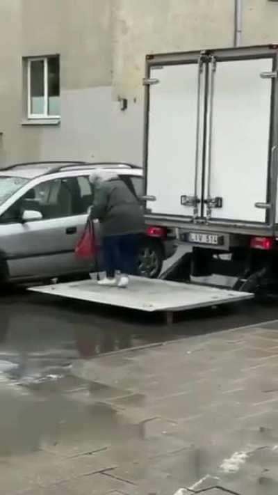 courier in lithuania helping old lady to get to her car