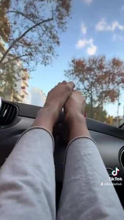 Cute bare feet driving through the city