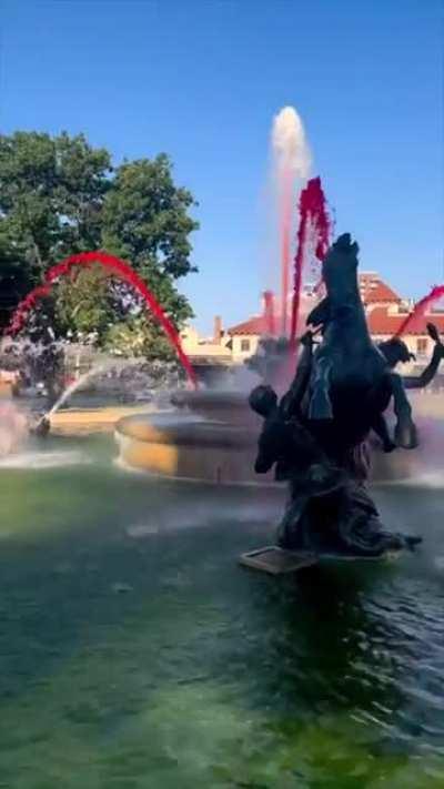 Pouring red dye into a public fountain