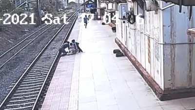 Rescue of blind woman's son who falls onto train tracks in front of oncoming train (new angle)