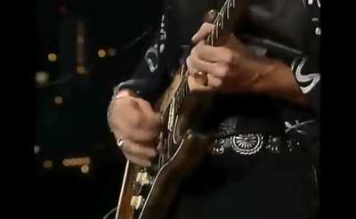 Stevie Ray Vaughan's guitar string snaps mid-solo, yet he manages to continue the solo regardless. He and his guitar tech then perform a smooth af switch of guitars.