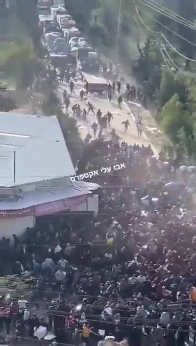 Hamas police members shooting at civilian Gazans near an aid truck.