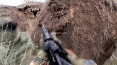 Ukrainian soldiers storming trench shoot two Russian soldiers as they exit a dugout with their arms raised. Unsure of units/location/date.