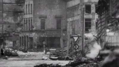 German civilian in Cologne changes pace as tracers fly in March 1945