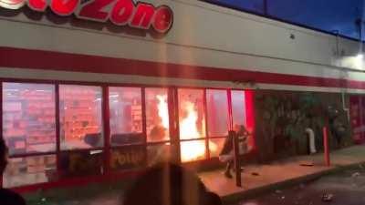 Protestors set an Autozone on fire in Minneapolis. They proceed to pose for pictures.