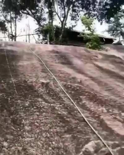 A monk climbs a steep slope without ropes. Nearby climbers are a little shocked by what they just saw.