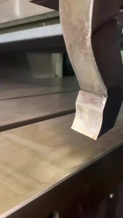 The smoothness of this metal chip being cut from a steel plate