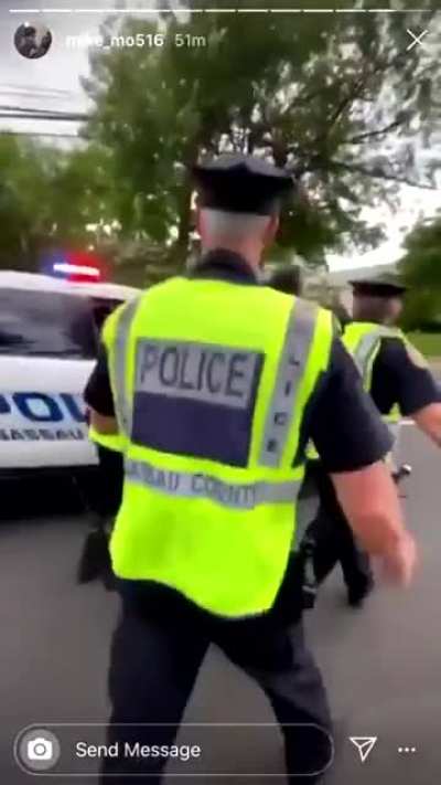 East Meadow, NY: a police officer abruptly stops walking so a protestor walking behind him will bump into him, so the other police can attack and arrest him.