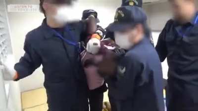 Guy resisting deportation at Narita airport.