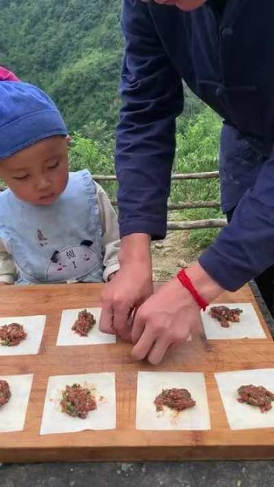 single father teaching his kid to cook traditional food