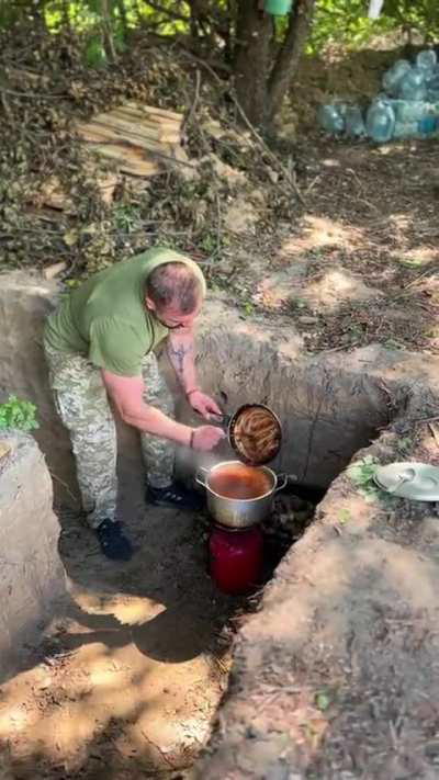 A Ukrainian soldier makes the team some well deserved hot food 