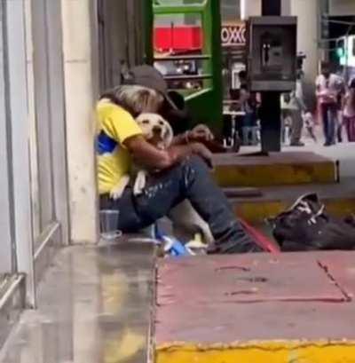 Someone’s dog approaches homeless man and seems to know what he needs.. 1 hug comforts two hearts!