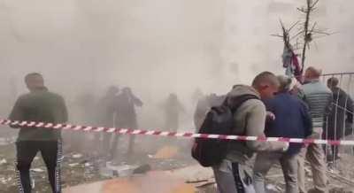 Onlookers scatter as more of the Belograd building collapses during rescue efforts. 