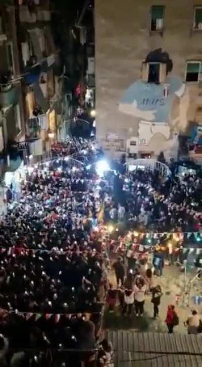 People celebrating Argentina win at the Maradona wall in Naples