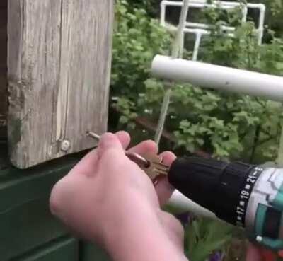 Using a power drill and a key to screw in the hook.