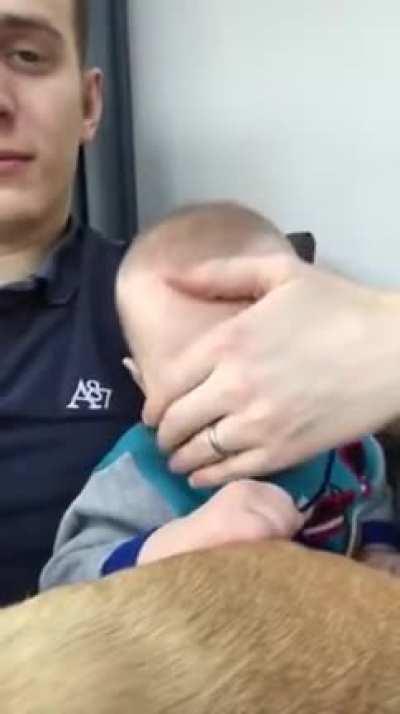 Daddy puts baby to sleep by sliding hand on his face