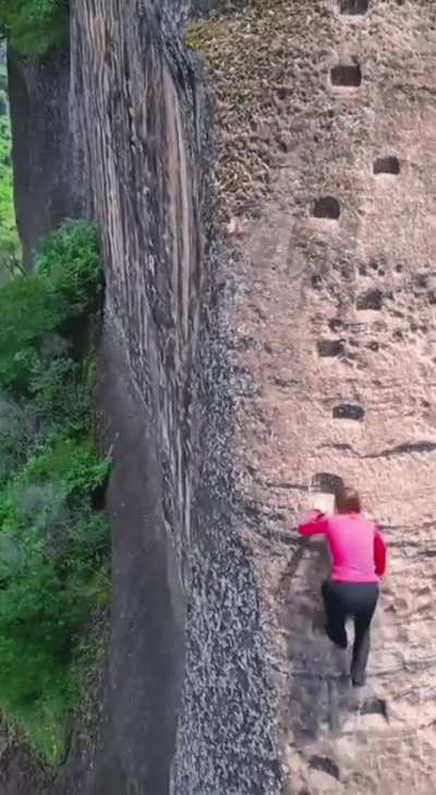 Climbing in footholds on mountain slope without tether