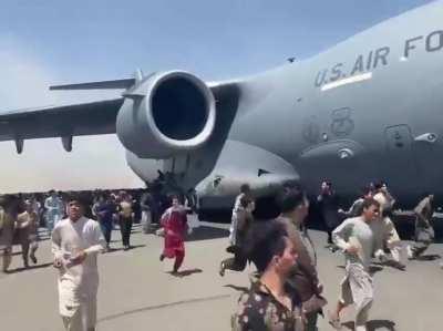 People attempting to flee Kabul on a US Air Force plane