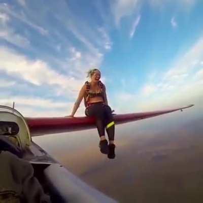 Woman poses mid-air on aircraft blade before sky jumping ✈️