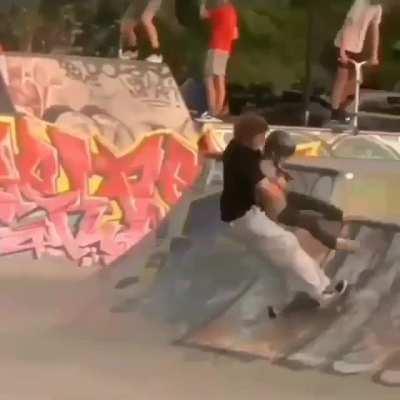 Skateboarder thinks quick and avoids collision with a younger skateboarder. He handles the event in an awesome way.