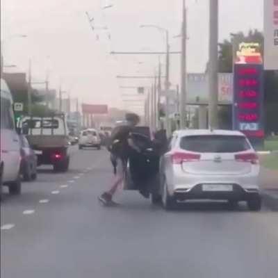 The car tries to smash the bike rider. Bike rider smashes back