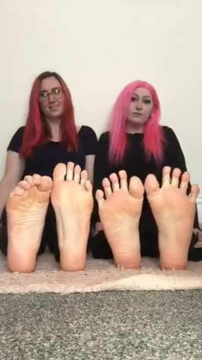 Two sisters spreading their toes side by side