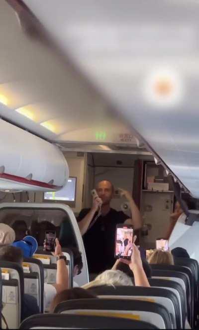 Leader of a particularly cult-like MLM takes over the mic on a public flight to do a rap