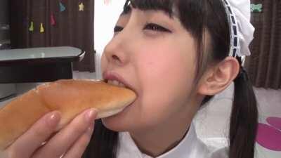 Cute Asian eats a hotdog