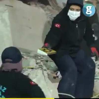 Turkish disaster relief workers showing respect to a Mus'haf of Qur'an