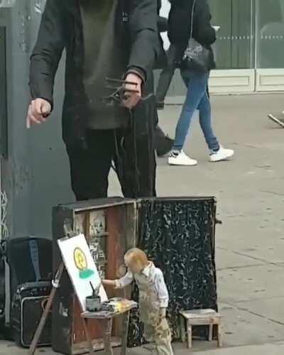 Man uses a marionette to paint