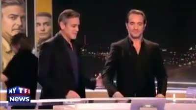 George Clooney and Jean Dujardin carefully listening to instructions before a tv show