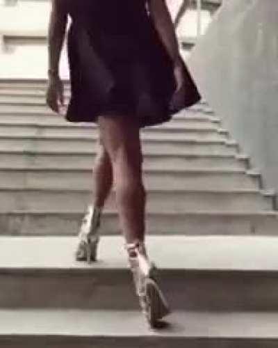 A Women in heels walking up the stairs.