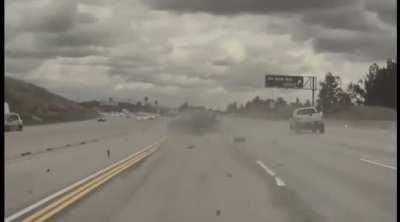 Kia flies in the air after loose wheel from pickup truck hits it on California highway