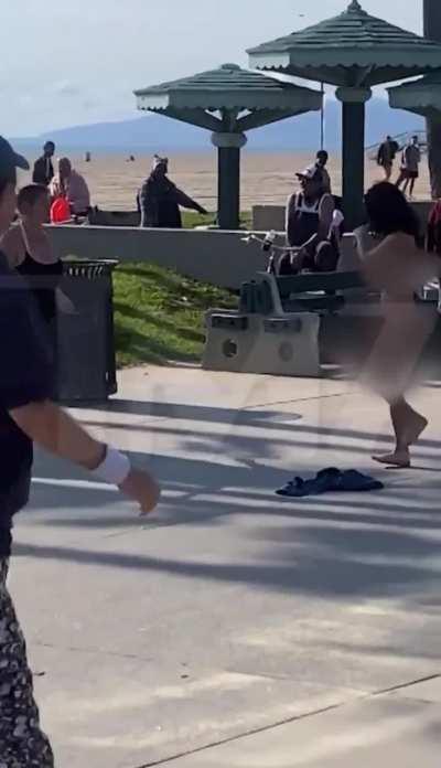 Naked woman gets in stick on stick combat in Venice