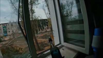 Ukrainian soldier firing at a Russian position where an explosion takes place. Toretsk, October 2024