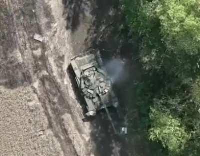 Ukrainian drone drops a grenade right into the hatch of a Russian tank, causing an instant cook off